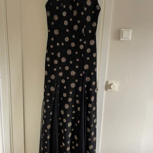 Fest klänning stl 48  - Fest klänning i svart och guld. Stl 48. Dragkedja där bak och är inte öppen vid bena utan det är täckt. Om du är intresserad så finns mer bilder. 99 krfrakt köparen står för frakten. Står ej för postens slarv! 