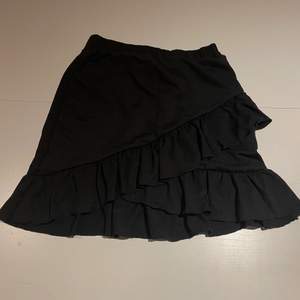 Det är en svart kjol med volanger. Stretchigt material. 