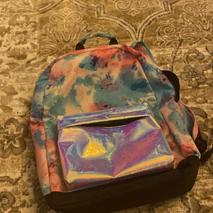 ryggsäck - den är rosa och lite lilla o mörk blå. Den har härliga färger och många fack passar bra till 8-10 åringar 