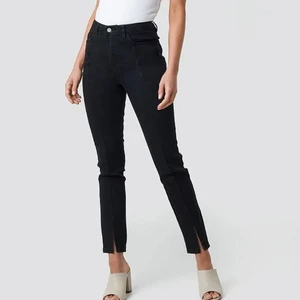 Jeans med slits - Svarta jeans med slits fram från nakd. Väldigt bra skick och är i storlek 36. Köparen står för frakten💕