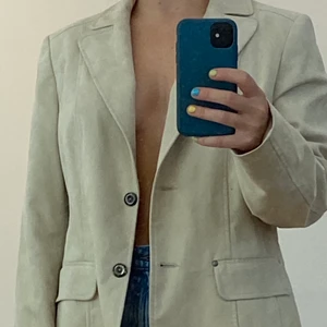 Beige kavaj - Säljer denna jättecoola beiga kavajen i supermjukt material, köpt second hand men i fint skick! Står storlek 42 på lappen men skulle absolut säga att den funkar på mindre också om man vill ha den mer oversized.
