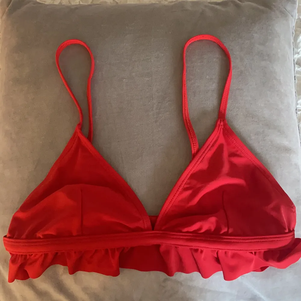 Röd bikinitopp med volanger. Den är endast testad och är i toppskick. Bikinin har justerbar knäppning i ryggen. Säljer pga att den är lite för stor för mig. Frakten är inte inräknad i priset!❤️. Toppar.