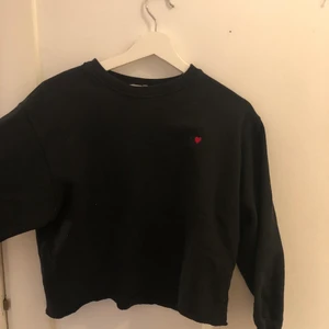 Svart sweatshirt  - En svart sweatshirt med ett rött litet hjärta, tyvärr för lite för mig men annars en supersnygg tjocktröja. Köpt från ett spanskt märke och tröjan är i storlek XS. Sparsamt använd och det finns inga defekter, skriv gärna i chatten om funderingar finns:)