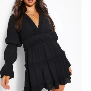 Klänning  - En helt oanvänd svart fin klänning med volanger från bohoo, säljer pga att den va nån storlek för stor på mig och hann ej skicka tillbaka, 150kr + frakt