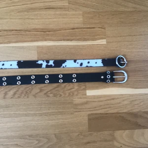 Skärp - Säljer två stycken skärp! Ett med komönster och ett svart med hål i! Komönster=105cm lång och 3cm bred!            Svart=100cm lång och 4cm bred!              70 kronor för båda och 40 för ett:)