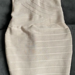 Bandageklänning endast prövad. - Säljer motvilligt min fina bandageklänning i beige. Jag älskar den men det blir inte att jag använder den & nu är det flyttrensning som gäller! Strl är S men pga att jag klippt bort lappar i ryggen kommer jag inte ihåg märke på den.