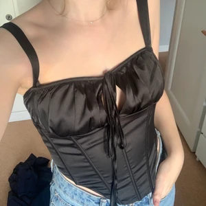 korsettopp strl S - 🖤skitfin och festlig korsettopp från shein! strl S. är i nyskick då den aldrig är använd, jag har dock klippt bort iläggen vid brösten. köparen står för frakten.