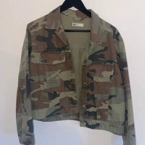 Jeansjacka - Jeansjacka i camouflage mönster från gina tricot. Brukar ha strl M men gick upp en strl för att få den mer oversized. Bra skick!