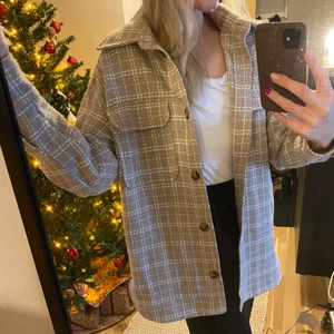 Beige skjort-jacka - En beige skjortjacka med vita rutor. Perfekt vår och höstjacka! Använd ett fåtal gånger. Strl S. Köparen står för frakten:)
