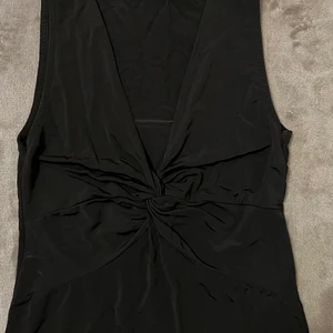 Svart topp/H&M - Svart topp från H&M, snygg detalj vid bröstet. 