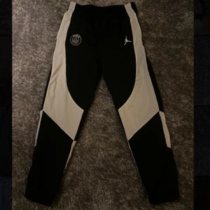 Psg Jordan trackpants!!💧 - Runda Psg badgen är riktigt fet, gjord av tjock tyg som är hård och sitter som ett märke utanpå byxan och som INTE är ett märke som är tryckt. Märket där bak med jordan och psg loggan är av tjockt nice gummi som är stabilt! Säljer nu mina Psg Jordan trackpants…