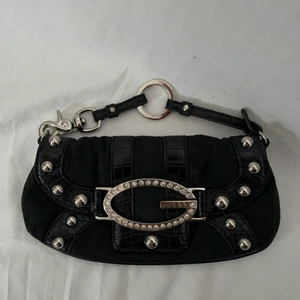 Svart guess väska - KÖP DIREKT FÖR 200! Guess väska köpt second hand. Inget äkthetsbevis finns tyvärr men allt tyder på att den är äkta! Köpare står för 48kr frakt. Säljer vid bra bud. Väskan är i gott defetfritt skick. Högsta bud 150kr. Budgivning avslutas 24h efter senaste bud och markeras med att plagget markeras sålt så buda på privat!