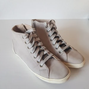 Beige sneakers från Wera strl 39 - Beige sneakers från Wera i fint, supermjukt skinn. Dragkedja vid ankeln. Fint använt skick. Uppfräschande och borstade. 