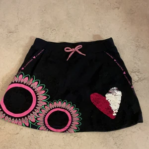 Svart kjol med olika färger - Desigual kjol med väldigt fina färger i strl:146-152. Är lite tjock i material. Är i ny skick!