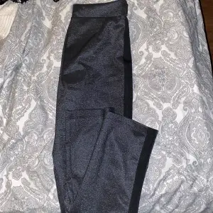 Kostym byxor i ett bra material. Glittrar och har en svart detalj på sidan. Lite vida vid fotleden och sitter tajt på bena resterande. 