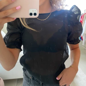 Svart genomskinlig topp med puffärmar  - Helt ny superfin svart genomskinlig tröja med puffärmar.  Köparen kommer att stå för frakten på 24kr.