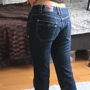 Snygga low waisted jeans  - Ett par low waisted jeans som är köpta secondhand i Stockholm. Byxorna bassar bra i längd för mig (jag är 160 cm). Byxorna har ett mönster med stras mönster bak och större diamant detaljer vid fickorna.