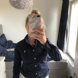 Skjorta från Ralph Lauren - Snygg marinblå skjorta från Ralph Lauren. Endast använd en gång så i nytt skick! Är storlek 4 vilket jag trot motsvarar xs/s. 