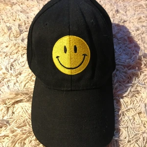 Keps - Svart/gul keps, one size. Märket fram är broderat och kardborre spänne bak.