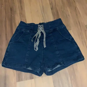 Mörkblåa shorts - Skit snygga mörkblåa shorts med snörnings detaljer framtill och dragkedja där bak  