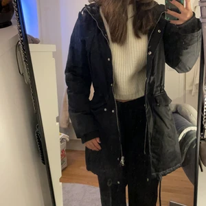 Svart trenchcoat  - Svart trenchcoat från lager 157. Den har knappar och dragkedja som stängning. Två fickor på sidorna. Den har luva med lurv innuti. Det går att spänna åt den i midjan. Den har lite lurv innuti i ryggen. Använd fåtal gånger. Skriv för fler bilder💕 köparen står för frakten⚡️