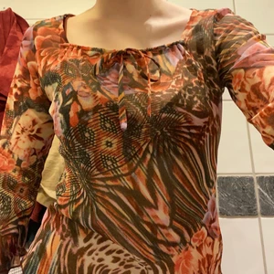 Blommig tröja - Jättesöt blommig tröja i mesh material med gullig rosettdetalj. Köpt på humana, bra skick. Påminner lite om 2000s stil 💕