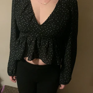 Blus-topp - Väldigt fin Svart blus-aktig tröja med vita prickar, snörning vid ryggen i storlek M. Kan mötas upp i Billinge eller Eslöv, köparen står för frakten
