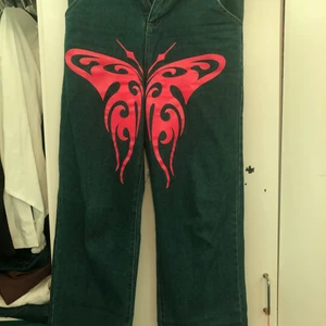 Mörkblåa jeans med rosa fjäril, strl M - De passar jätte fint på en storlek M, kommer ej in i dessa längre och är bara använda ett par gånger.