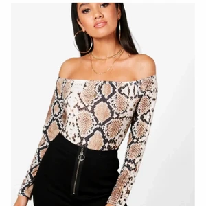 Off shoulder body snakeprint - Jättesnygg off shoulder body med snake print. Ser ut som på bilderna ovan. Storlek xs-s. Använt endast en gång. Bodyn är i toppen skick, som ny! Kan skicka flera bilder via meddelanden. 