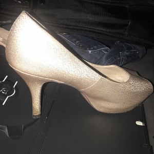 Högklackade open toe skor i guld färg  - High heel guldfärgade skor med öppen tå från Menbur.   Skorna är i jätte fint skick. Det är endast under man ser att dom är använda. Dom är tyvärr lite för små för mig annars hade jag aldrig sålt dom. Dom är sååååå snygga!! Nypris 1100