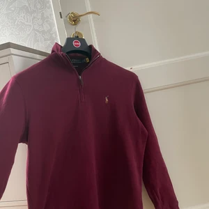 Ralph Lauren half zip - Säljer denna vinröda half zip från Ralph Lauren. Inköpt i höstas och använd vid väldigt få tillfällen. Skick 9,5/10! Ganska stor i storleken. Kom privat för fler bilder eller frågor!