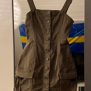 Grön jeansklännig - En militärgrön klänning från H&M som är använd 5 gånger. Sitter väldigt fint och är bekväm att röra sig i. 