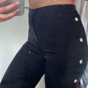Svarta byxor med knäppningar  - Svarta byxor i storlek 34. Pris kan diskuteras 