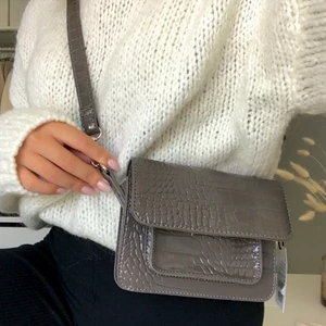 Hvisk väska - Superfin väska från Hvisk i en fin grå/brun färg. Helt oanvänd med alla lappar kvar, nypris 699kr