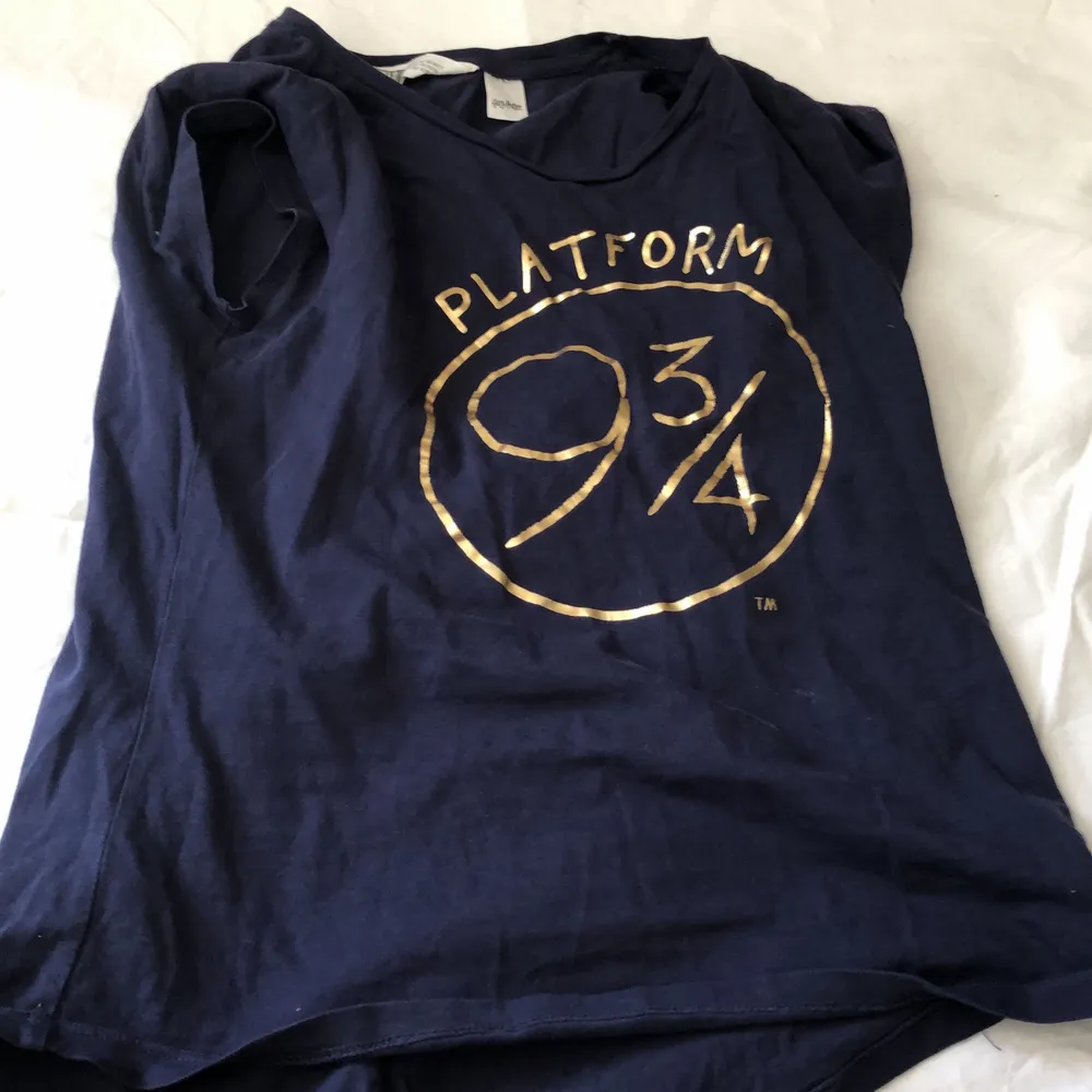 Blå Harry Potter tröja med 9 3/4 tryck och gyllene kvicken på ena armen, pris kan diskuteras 💕. T-shirts.