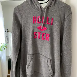 Skön grå HOLLISTER hoodie med cerise rosa logga. Våfflad effekt o luvan. Använd en del men i fint skick. Står M men är rätt liten M så passar lätt en S också!