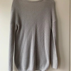 Grå stickad tröja med djup rygg - En fin grå stickad tröja med djup rygg i storlek xs från NAKD. Plagget har använts en gång och är därmed i nyskick💕💕