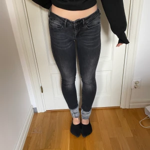 Jeans från Guess  - Grå jeans med detalj nedtill från Guess. 