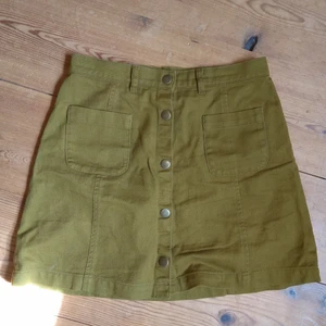 Olivgrön kjol från Monki - Skitsnygg olivgrön kjol från Monki som inte kommer till användning länge. Miniskirt men inte för kort för mig som är 159cm! Skriv för mått eller fler bilder<3