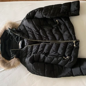 Vinterjacka - En kortmidjad vinterjacka. Det har ett litet hål vid pälsen men det går att sy ihop. 