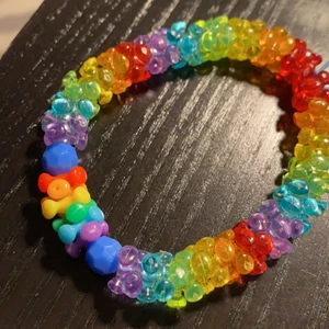 Armband - Ett egengjort regnbågsarmband men elastisk tråd, så passar alla sorters storlekar. Även en liten regnbågsfärgad detalj i mitten av armbandet som ni ser på 3e bilden.