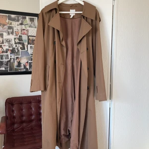 Brun lång trenchcoat  - Perfekt Brun lång trenchcoat i storlek M från HM till våren 🌿🌱  knappt använd, köparen står för frakten 66 kr🌞  kan tänka mig att gå ner i pris vid snabb affär 🦋så ge prisförslag  