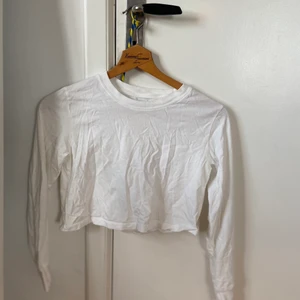 Vit croppad långärmad - Väl använd (men i bra skicka) vit långärmad croptop. Väldigt bekväm och passar till allt! Frakt tillkommer.