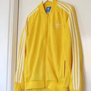 Sommarens viktigaste färg!  - Med denna adidas firebird zip har du garderat garderoben med sommarens viktigaste färg: Knallgul . Knappt märkbart hål på vänster axel (se bild 3)