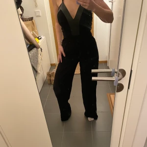 Byxdress med skinndetaljer - Byxdress med skinndetaljer och kryss i ryggen, jag är 160 cm. Fint skick. Köparen står för frakten 