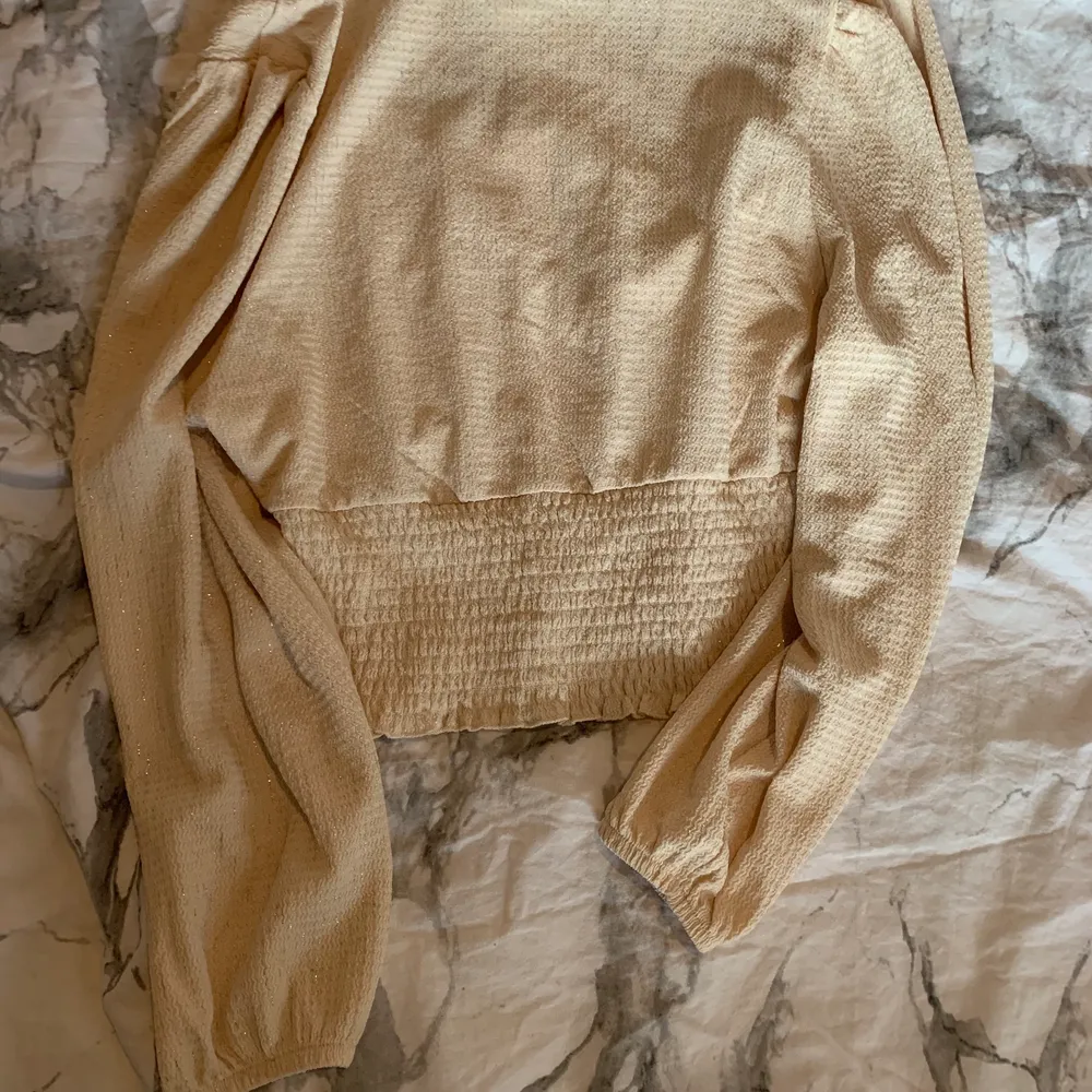 Blus i storlek M från Monki, aldrig använd 💓 Den är ljusbeige och lite glittrig. Passar jättefint och är i fint material. Tveka inte att höra av dig om du har frågor eller vill ha fler bilder 🌟 FRAKT INKLUDERAD I PRISET!. Blusar.