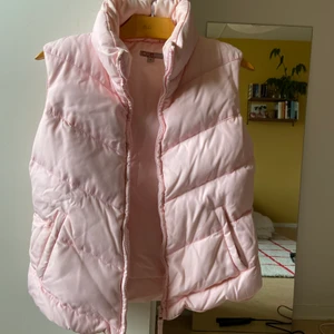 Dunväst i nylontyg strlk M - Ljusrosa dunväst i använt skick. Säljer pga. för stor storlek, västen är i M jag är vanligtvis en XS/S.    