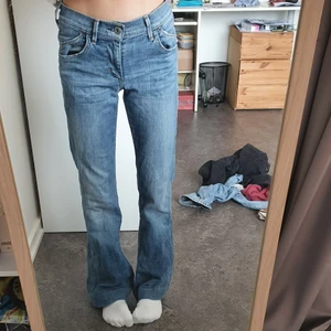 Jeans  - Ett par blå, lågmidjade och utsvängda jeans. Storlek 24/xs
