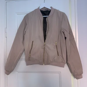 Beige Bomber jacka stl S - Fin bomber jacka stl S. Färg beige med guldkedjor. Behöver tvättas. Se bild. 