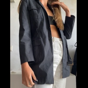 Svart kapp - En svart kappa som jag säljer på grund av att jag inte fått så mycket användning utav den. Den är i storlek m men är lite lite i storleken och personen på bilden har i vanliga fall storlek s